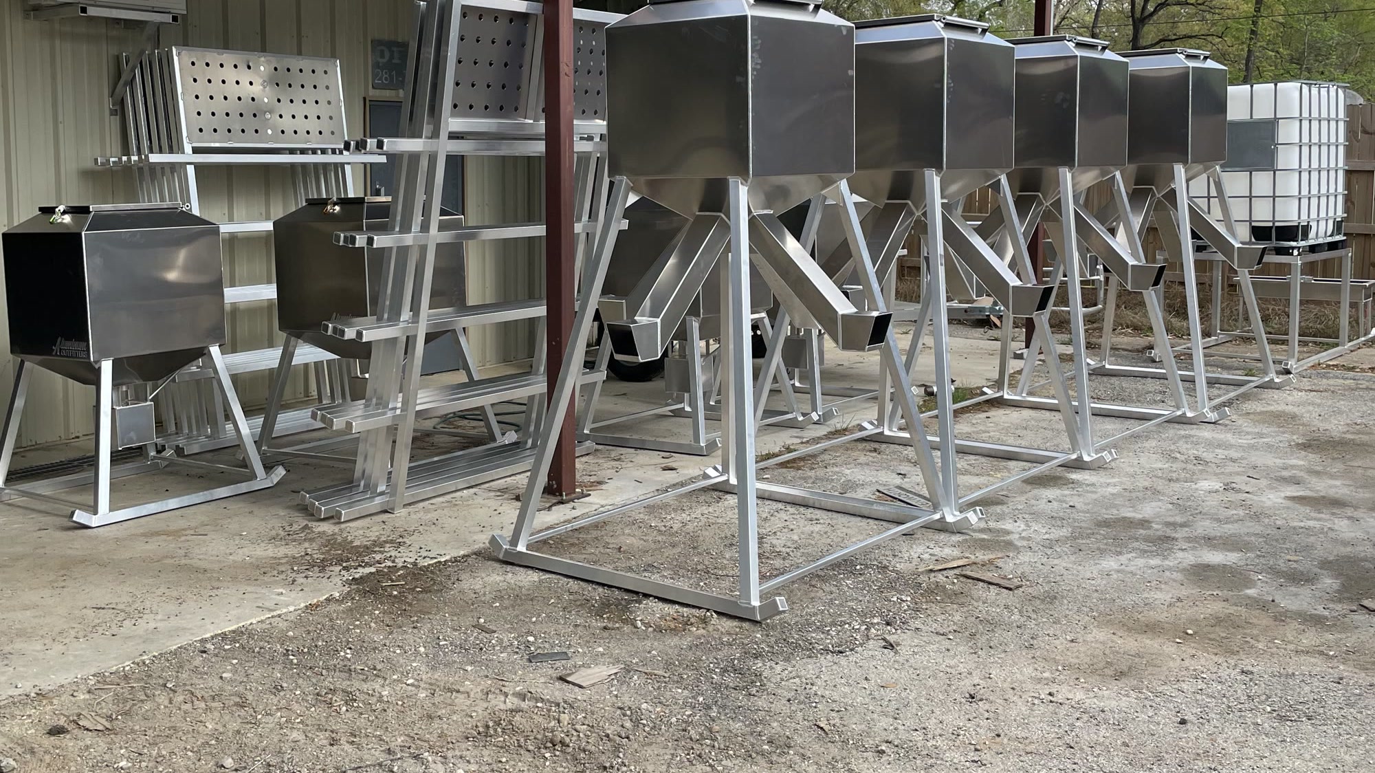 A row of Aluminum Outfitters feeders under the carport at the New Caney shop.