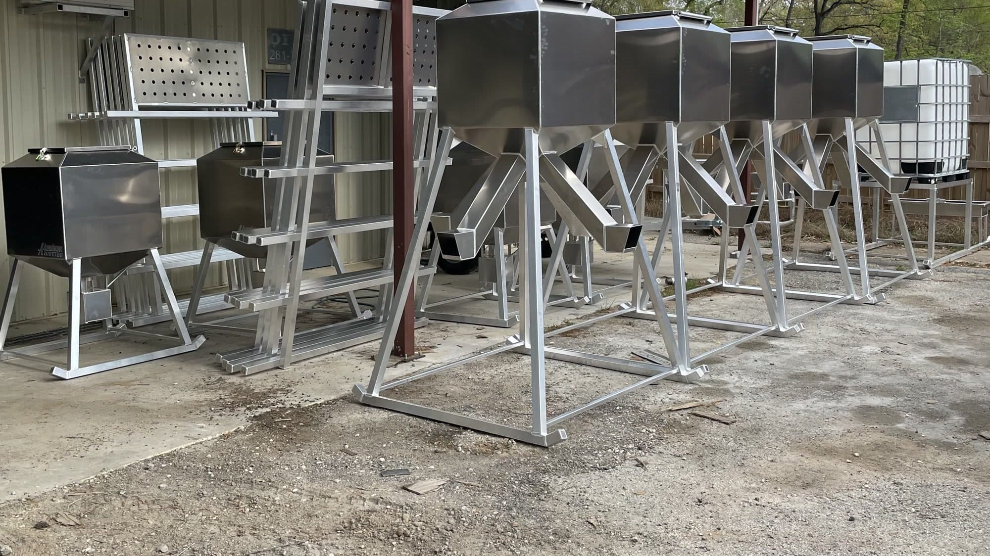 A row of Aluminum Outfitters feeders under the carport at the New Caney shop.