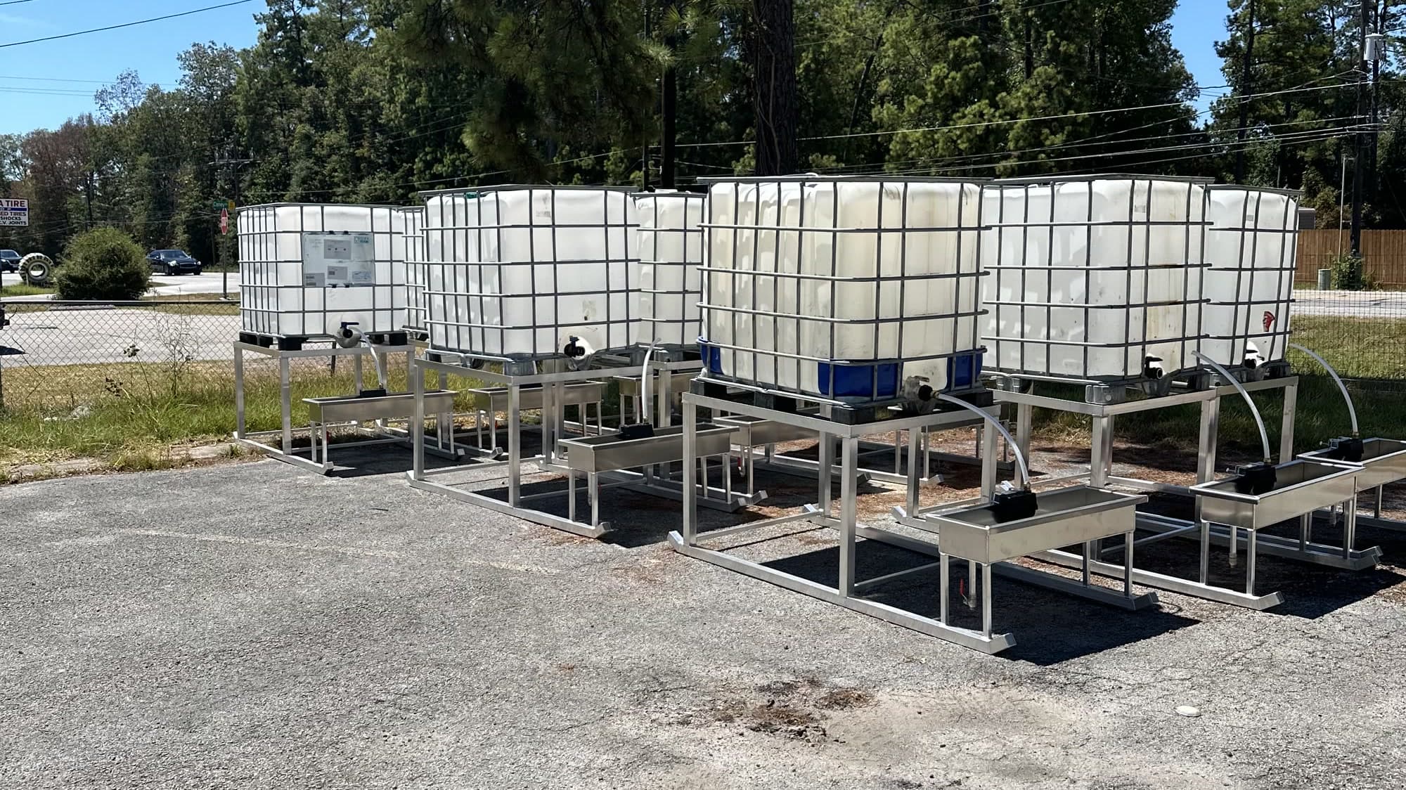 A row of aluminum water troughs in the yard at 19363 FM 1485.